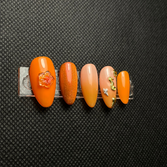Faux ongles Peach Punch orange pêche avec ornements dorés C'Sha Nails
